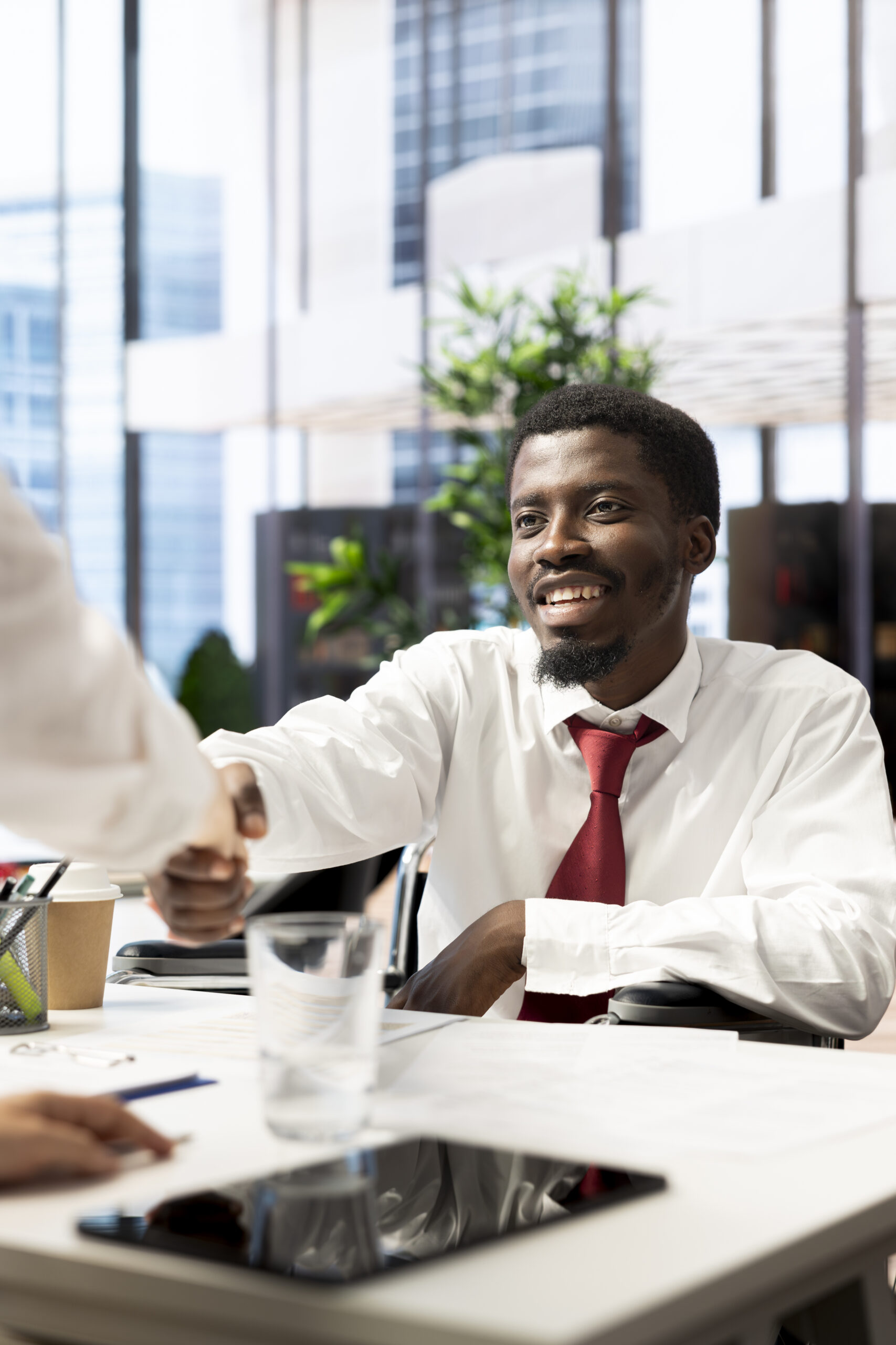HR employee does greeting handshake with happy candidate in wheelchair HR employee does greeting handshake with happy candidate in wheelchair after determining he possesses needed skills. HR manager shakes hands with cheerful person with disability after evaluation